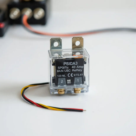 Compact 40 amp SPDT mini relay with terminals and simple color-coded wiring on a workbench