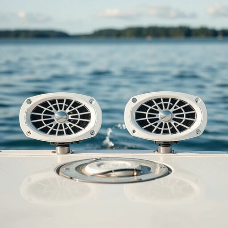 Marine audio speakers mounted on a boat exterior with water and calm horizon in the background